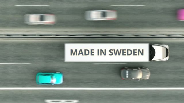 Trailer trucks with MADE IN SWEDEN text driving along the road. Swedish business related loopable 3D animation