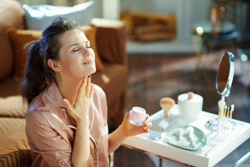 relaxed woman with jar applying neck cream