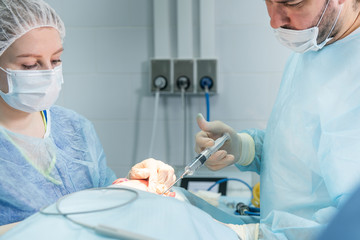 Doctor making injection during facial surgery operation