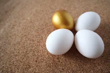 Golden and white eggs lie on the table in the form of a flower. Happy easter concept, top view, copy space.