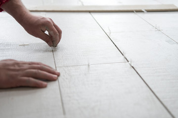 worker installing the ceramic wood effect tiles on the floor