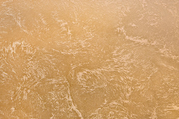 Spotted beige wall texture, decorative plaster. Decorative wall covering - sand
