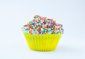 Cupcake with blue cream and colored sprinkles isolated on a white background. Copy space