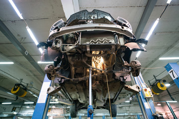 Dismantled car hanging on a lift in a car service