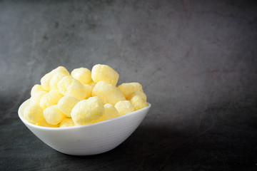 Corn sticks in a bowl on a dark background