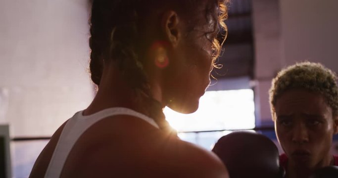 Two mixed race women training in boxing ring