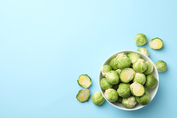 Bowl with brussels sprout on blue background, top view