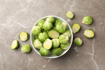 Bowl with brussels sprout on grey background, top view