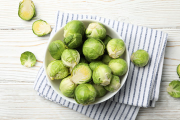Bowl with brussels sprout on wooden background, top view
