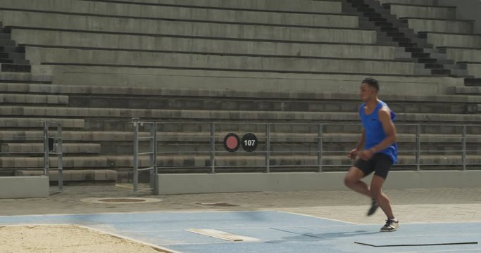 Close up view of mixed race athlete doing long jump