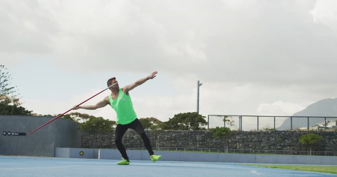 Side view of caucasian athlete throwing javelin