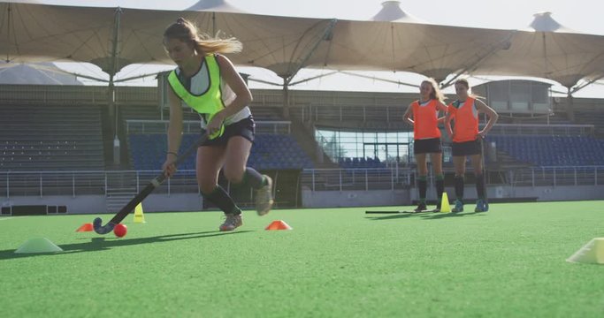 Female hockey players training on a field