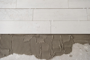 Ceramic wood effect tiles and tools for tiler on the floor