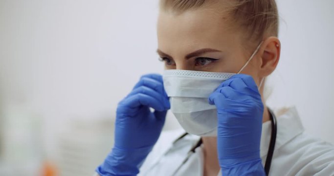 female doctor putting on protective mask at clinic