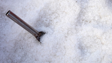 White crystallized sea salt, with a small metal scoop.