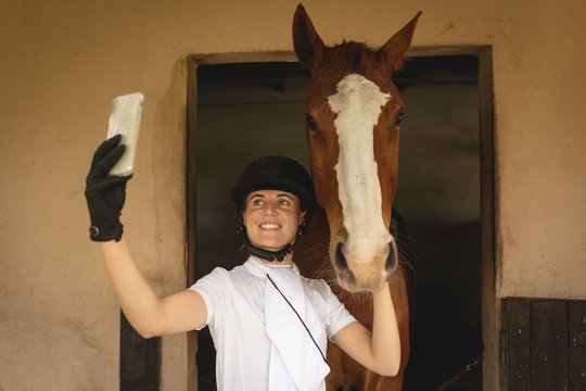 Caucasian woman taking selfies with her dressage horse