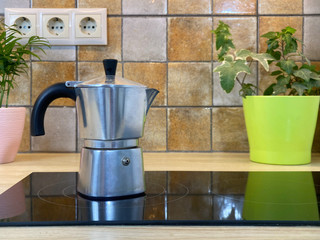 Pouring hot coffee from mocha pot to cup, close-up