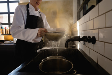 Caucasian chef dripping pasta