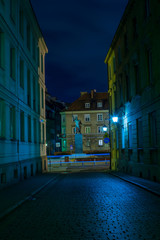 Streets of Warsaw Old Town by the night. Kapitulna street with view on Kilinski statute.