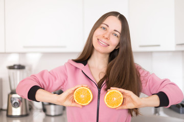  woman in pink overalls, kitchen, orange fruit