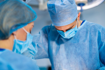 Spinal surgery. Group of surgeons in operating room with surgery equipment. Modern medical...