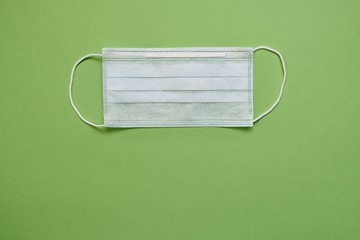 Medical protective masks on a green background. Disposable masks to protect a person from viruses, bacteria and dust. For protection against coronavirus 