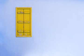Yellow old wooden window on the blue wall