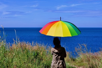 Beautiful women with colorful umbrellas on a hill overlooking the seaside of Koh Samet.