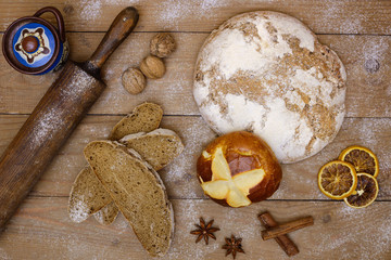 Fresh bread and bread slices on wooden planks with a rolling pin bread in retro style, nuts and spices. Top view, brochure and banner concept for grocery store and bakery.