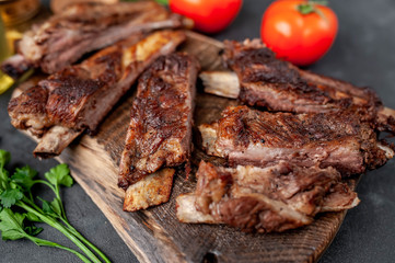 pork ribs with spices, tomatoes and herbs on a stone background
