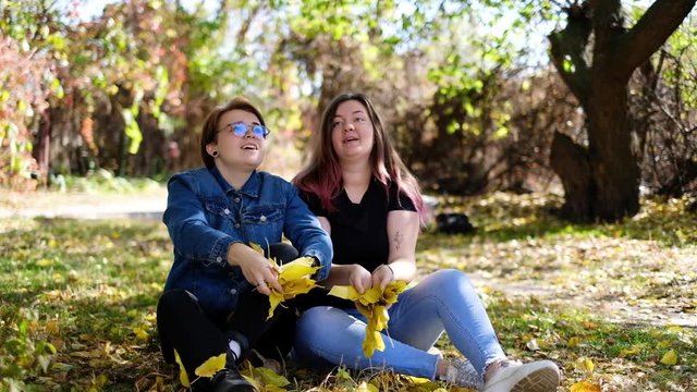 Charming young women kissing gently loving each other stroking touching face skin enjoying romantic tender moments on picnic date in the countryside.