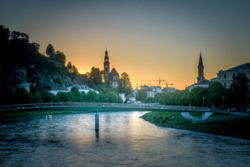 sky line of Saluzburg city over the salzach river at sunset