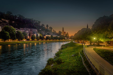 Fototapeta na wymiar sky line and city lights of Saluzburg city over the salzach river at sunset