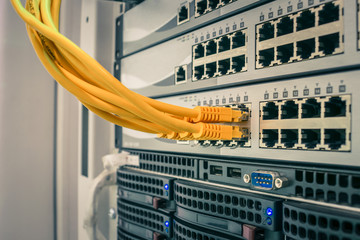 A bunch of yellow utp cables connect to the network interfaces of the Internet router. Switching...