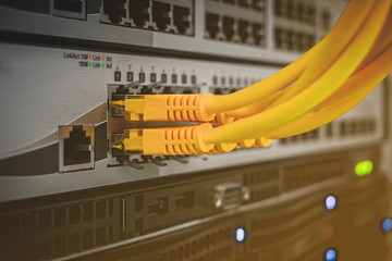Switching wires are connected to the server switch. The technological concept of a modern data center. A bunch of yellow utp cables connect to the network interfaces of the Internet router.