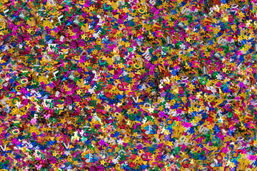 Confetti close up, various colors and shapes of metallic confetti, horizontal background