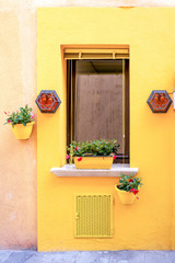 Facade of old house with window, flowerpots with flowers and lanterns