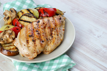 grilled chicken fillet with vegetables grill on a light background