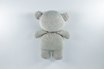a small knitted toy grey bear cub from the back
