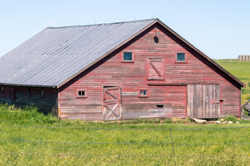 Obraz premium An old barn in a grassy field. High quality photo