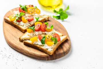 Cherry tomatoes cottage cheese toasts. Selective focus, copy space.