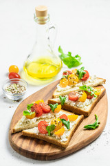 Cherry tomatoes goat cheese toasts. Selective focus, copy space.