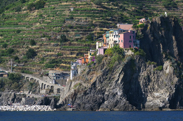 Colorful houses of Manarola, a Cinque Terra mountain village and tourist destination on the steep coast of the Mediterranean sea in Liguria, Italy, copy space