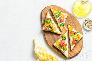 Cherry tomatoes cottage cheese toasts.Top view, copy space.