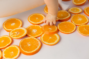 the child is holding a slice of orange orange. child's hand. fruits