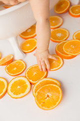 the child is holding a slice of orange orange. child's hand. fruits