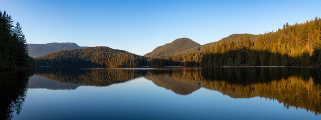 Beautiful and Vibrant panoramic view of a lake surounded by Canadian Mountain Landscape during sunset. Taken in White Pine Beach, Port Moody, Vancouver, British Columbia, Canada. Panorama