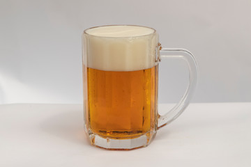 glass of beer with foam isolated on white
