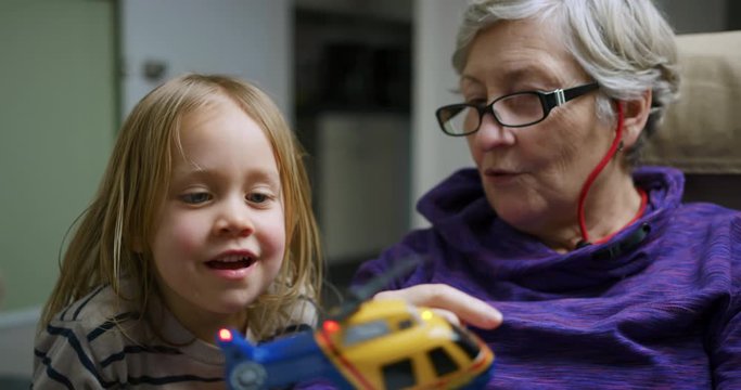 Little preschooler showing his grandmother a toy helicopter