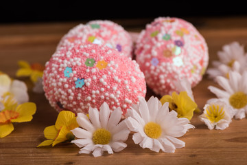 Obraz na płótnie Canvas pink with white sprinkles easter eggs and spring flowers